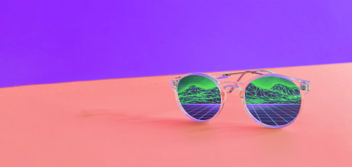 Eine Sonnenbrille spiegelt eine digtale Landschaft vor einem Lila-roten Hintergrund